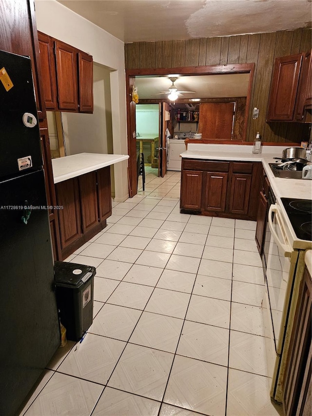 kitchen featuring ceiling fan, white range with electric stovetop, kitchen peninsula, and wood walls