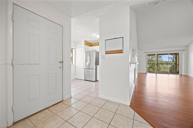 hallway featuring light tile patterned floors and a textured ceiling