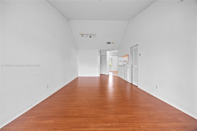 spare room featuring hardwood / wood-style flooring and vaulted ceiling