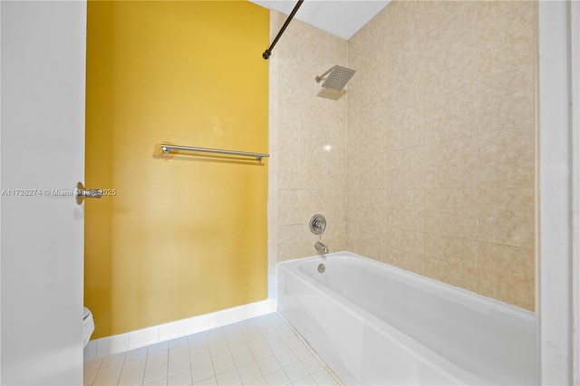 bathroom featuring tiled shower / bath, toilet, and tile patterned flooring