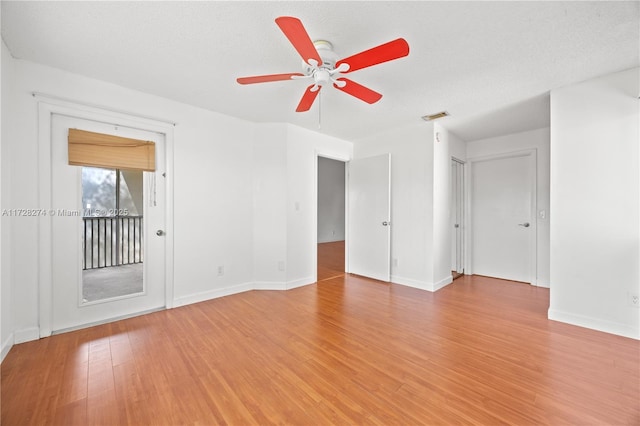 spare room with a textured ceiling, ceiling fan, and wood-type flooring