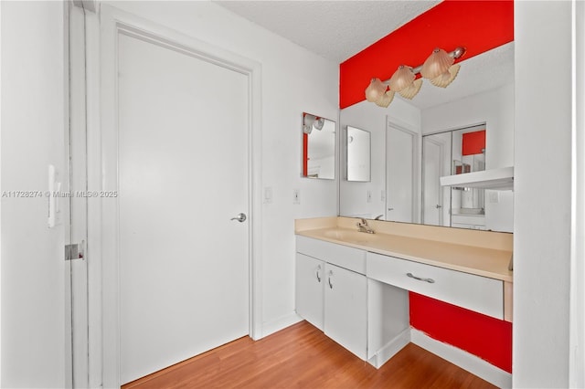 bathroom featuring wood-type flooring, a textured ceiling, and vanity