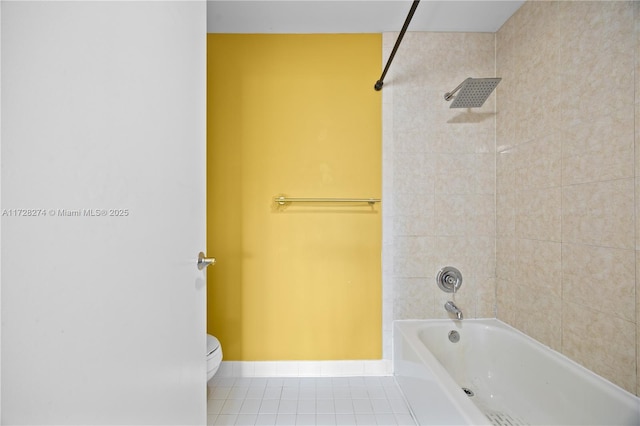 bathroom featuring toilet, tiled shower / bath, and tile patterned floors