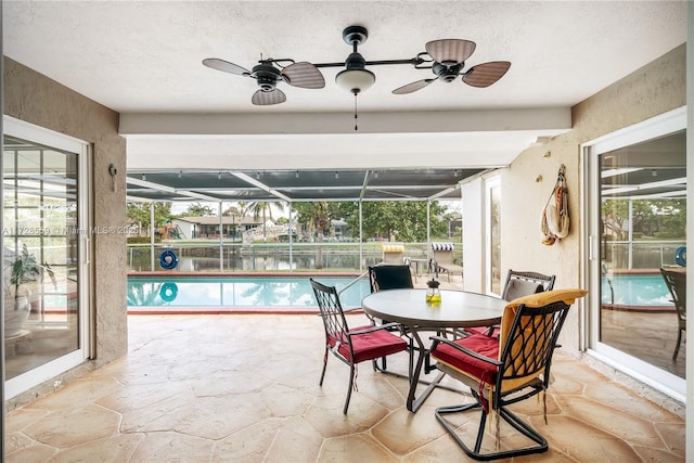 sunroom / solarium featuring ceiling fan and a healthy amount of sunlight