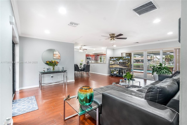 living room with ceiling fan, wood-type flooring, french doors, and ornamental molding