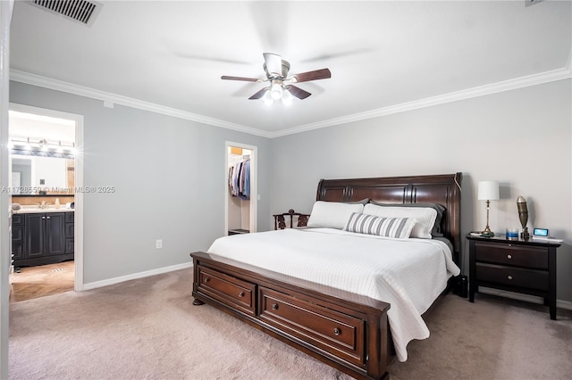 carpeted bedroom with ceiling fan, crown molding, connected bathroom, a walk in closet, and a closet