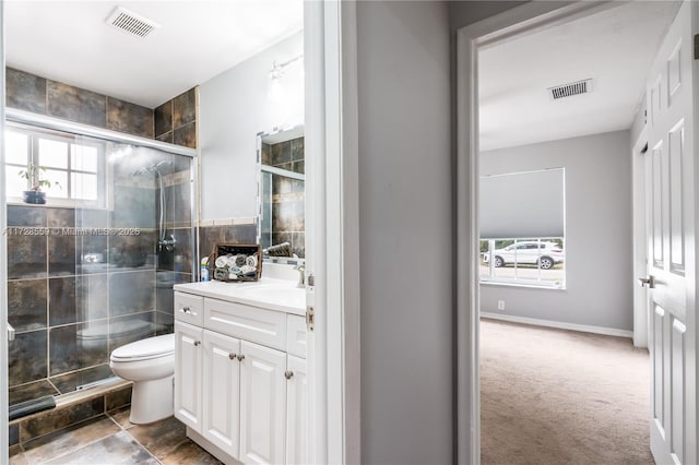 bathroom featuring toilet, a shower with door, and vanity