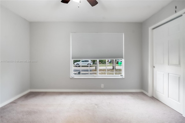 unfurnished bedroom with ceiling fan, light colored carpet, and a closet