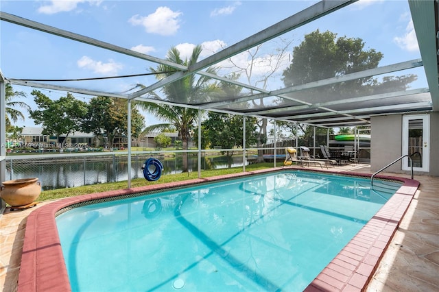 view of swimming pool with a patio area, a lanai, and a water view