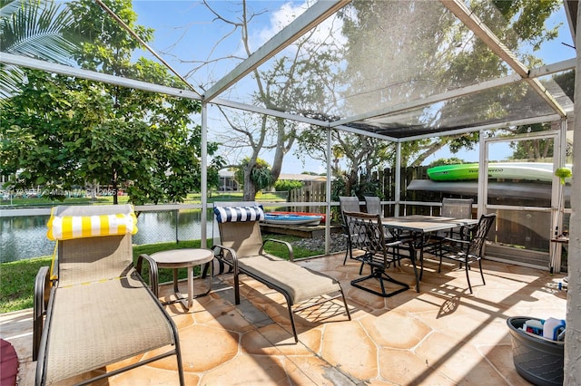 view of patio / terrace featuring a water view and glass enclosure