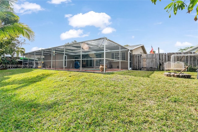 rear view of property featuring a lanai and a lawn