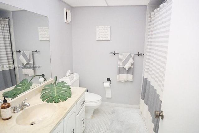 bathroom with toilet, vanity, and tile patterned floors