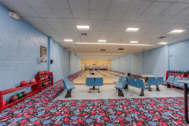 recreation room featuring a bowling alley and a paneled ceiling