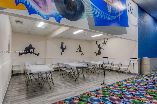 playroom featuring a drop ceiling and hardwood / wood-style flooring