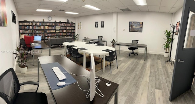 office space featuring a drop ceiling and light hardwood / wood-style floors