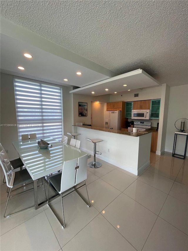 tiled dining room with a textured ceiling