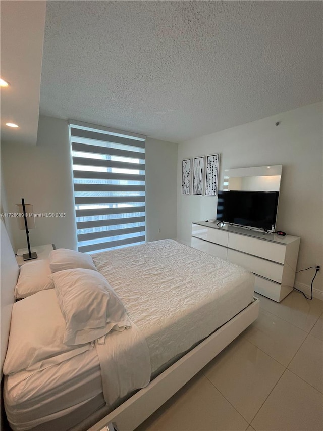 bedroom featuring a textured ceiling and light tile patterned flooring