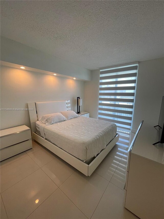 unfurnished living room featuring a textured ceiling and light tile patterned flooring