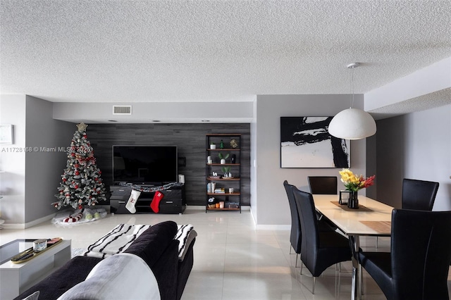 tiled dining area with a textured ceiling and built in shelves