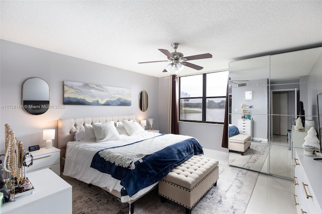 bedroom featuring ceiling fan and a textured ceiling