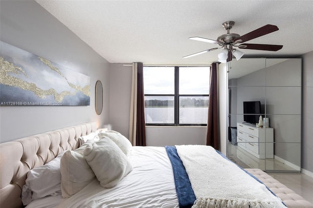 bedroom featuring ceiling fan and a textured ceiling