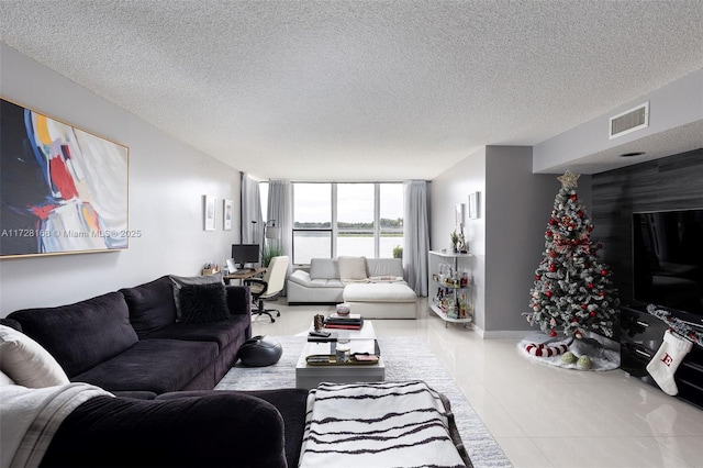 tiled living room with a textured ceiling and expansive windows