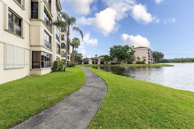 view of home's community with a water view and a lawn