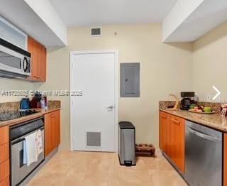 kitchen with light tile patterned floors, electric panel, and black appliances