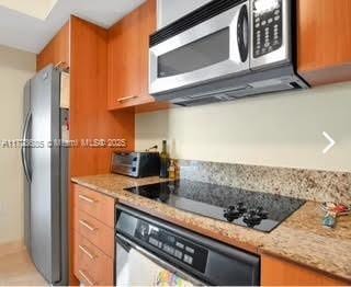 kitchen featuring stainless steel appliances and light stone countertops