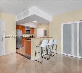 kitchen featuring a breakfast bar, appliances with stainless steel finishes, and kitchen peninsula