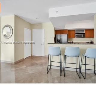 kitchen with a kitchen breakfast bar, stainless steel appliances, and kitchen peninsula