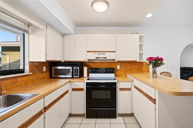 kitchen featuring electric stove, kitchen peninsula, decorative backsplash, light tile patterned flooring, and white cabinets