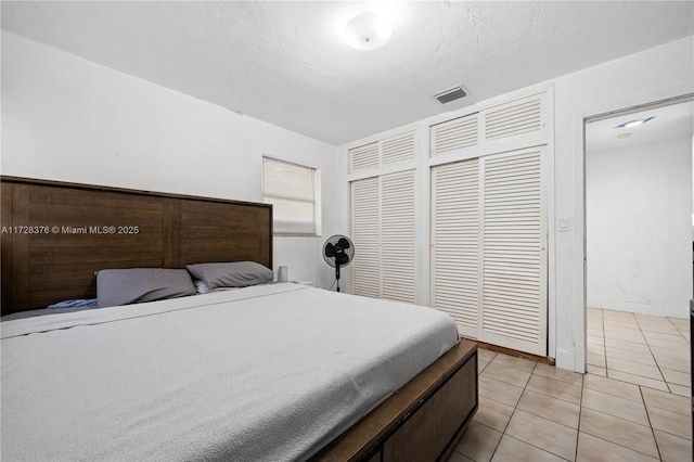 tiled bedroom featuring a closet and a textured ceiling