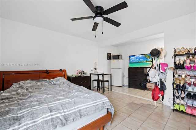 tiled bedroom with ceiling fan and white fridge