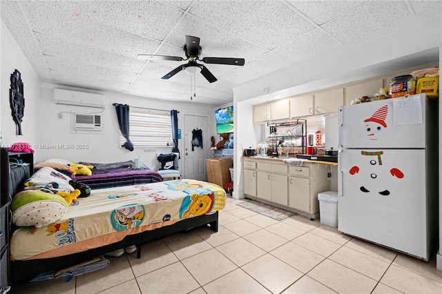 tiled bedroom with ceiling fan, an AC wall unit, white refrigerator, and a paneled ceiling