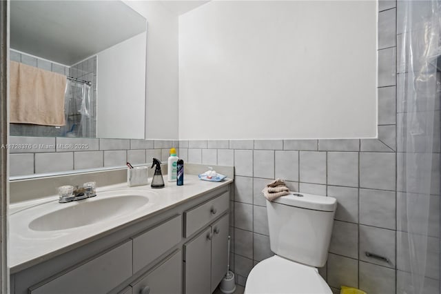 bathroom featuring toilet, vanity, tile walls, and a shower with shower curtain