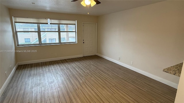 empty room with ceiling fan and wood-type flooring