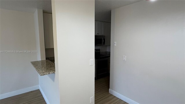 hall featuring a textured ceiling and dark hardwood / wood-style flooring