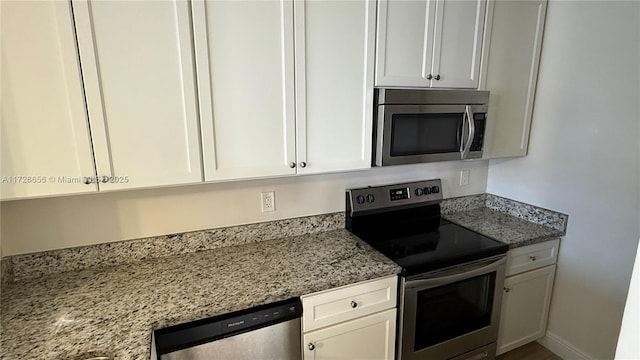 kitchen featuring appliances with stainless steel finishes, white cabinetry, and light stone counters