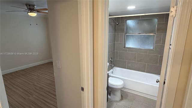 bathroom with toilet, tiled shower / bath combo, and ceiling fan