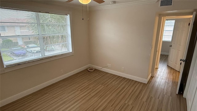 spare room with ceiling fan, a healthy amount of sunlight, crown molding, and light hardwood / wood-style flooring