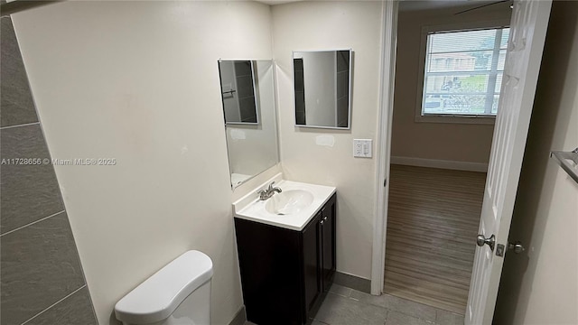 bathroom with toilet, vanity, and tile patterned flooring