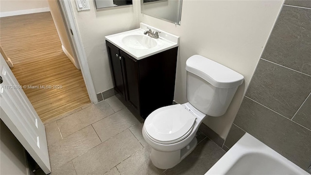 bathroom with toilet, vanity, and a bathing tub