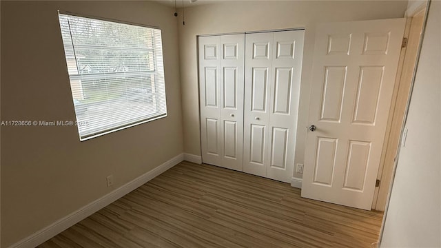 unfurnished bedroom with wood-type flooring and a closet