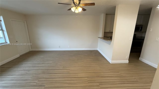 empty room featuring ceiling fan and light wood-type flooring