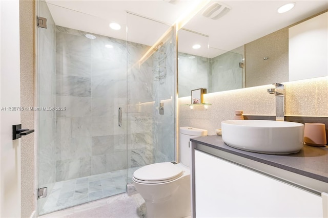 bathroom with tasteful backsplash, vanity, tile walls, toilet, and walk in shower