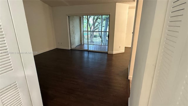 empty room with a textured ceiling and dark wood-type flooring