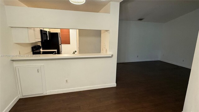 kitchen with black electric range, refrigerator, dark hardwood / wood-style floors, kitchen peninsula, and white cabinets