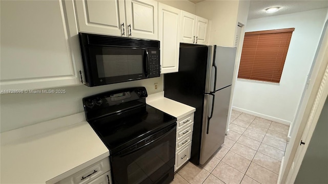 kitchen featuring light tile patterned floors, white cabinetry, and black appliances