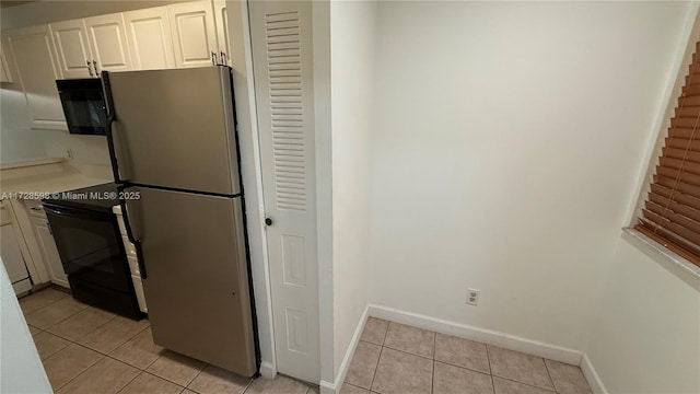 kitchen with light tile patterned floors, white cabinets, and black appliances